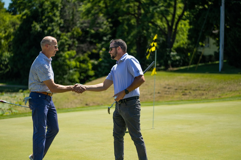 Golfers shaking hands on course greens